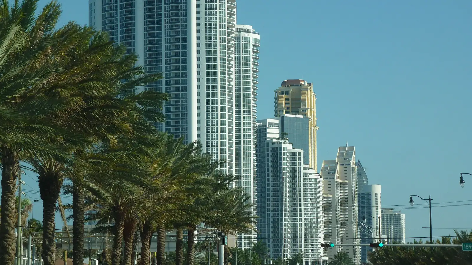 Oceanfront condominium towers and palm trees along Collins Avenue in Sunny Isles Beach, Florida